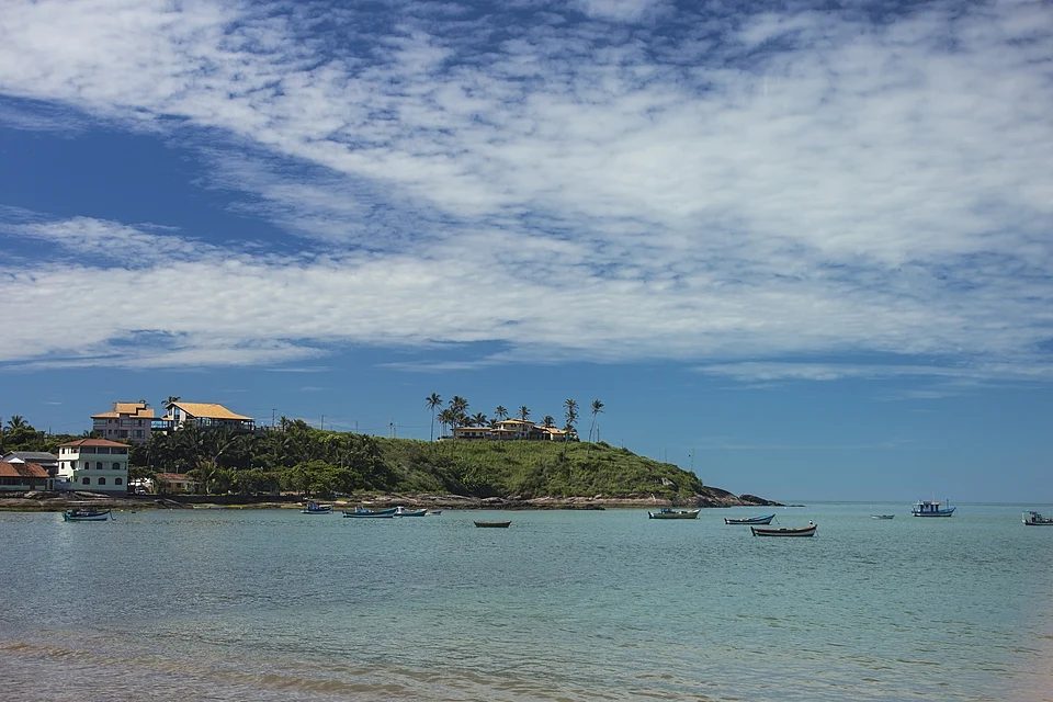 Vista da Praia de Meaípe com barcos ancorados e morro com casas ao fundo