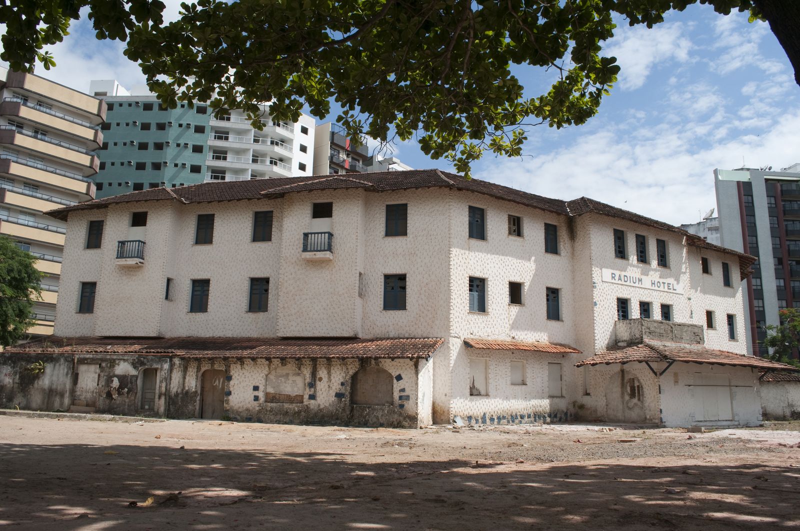Fachada do Radium Hotel, prédio branco histórico em frente à Praia da Areia Preta
